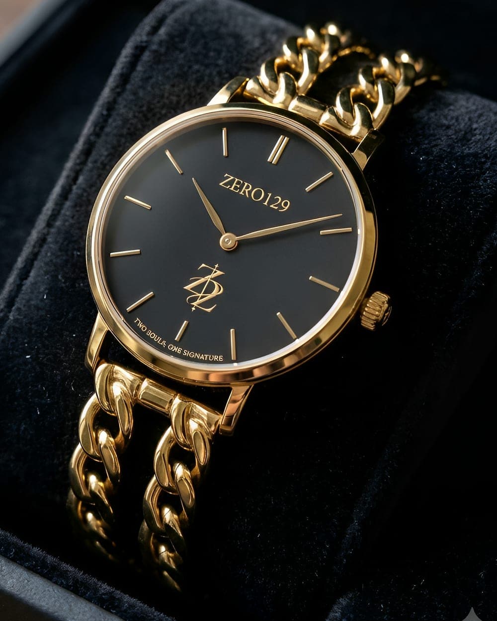 Zero129 gold watch with a black dial and double curb-chain bracelet in its velvet case